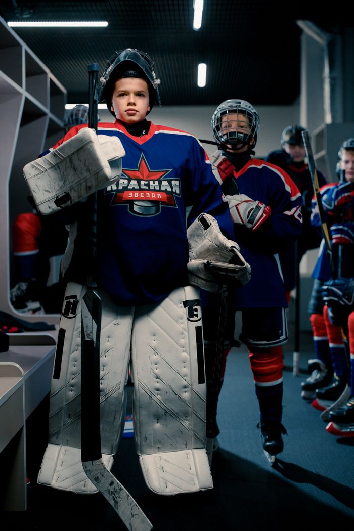 Young hockey players getting ready in the locker room, showcasing teamwork and determination.